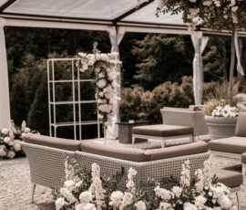 Elegante Hochzeitsfloristik von Gärtnerei Reinwald: weiße Blüten, Rosen und grünes Blattwerk schmücken den Lounge-Bereich der Hochzeitslocation. Lounge-Bereich zur Hochzeit mit weißer Blumendekoration, Rosen und grünem Blattwerk von Gärtnerei Reinwald Heilbronn.